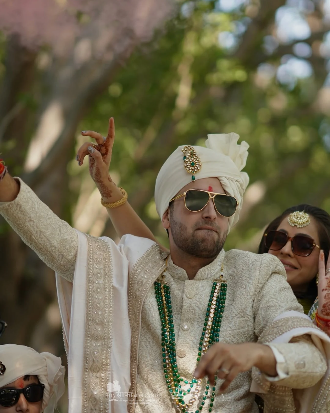Groom in an ivory wedding safa with emerald jewellery for Begumpet
